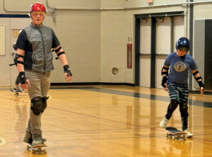  Image of two students skateboarding inside a gym